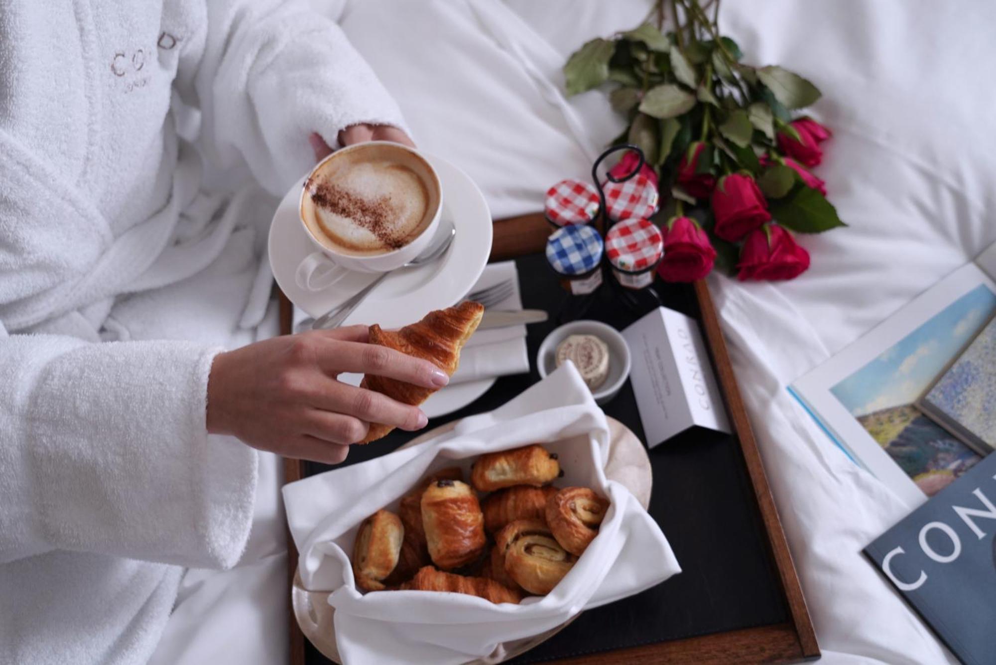 Conrad London St James Exterior photo A woman having breakfast in bed